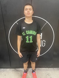 a young man standing in front of a basketball court