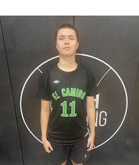 a young man standing in front of a basketball court