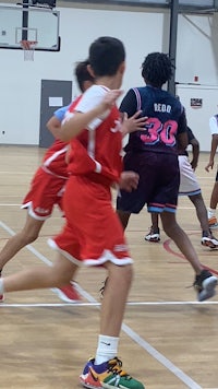 a group of boys playing basketball in a gym