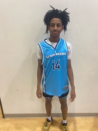 a young man in a basketball uniform standing in front of a wall