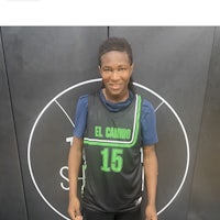 a young man in a basketball uniform standing in front of a wall