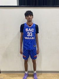 a young man in a basketball uniform standing in front of a wall
