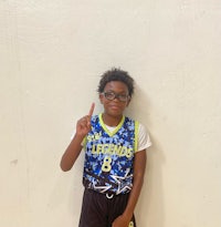 a young boy in a basketball uniform posing for a picture