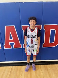 a young boy standing in front of a basketball court