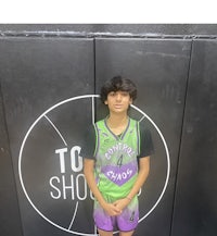 a young man standing in front of a basketball court