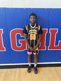 a young man in a basketball uniform standing in front of a wall