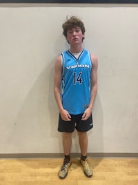 a young man in a blue jersey standing in front of a wall