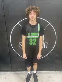 a young man standing in front of a basketball court