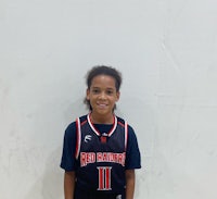 a young boy in a basketball uniform posing for a photo