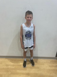 a young boy standing in front of a wall