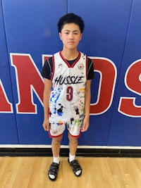 a young man in a basketball uniform standing in front of a wall