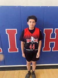 a young man standing in front of a basketball court