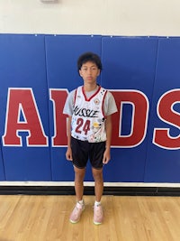 a young man standing in front of a basketball court