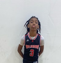 a young boy in a basketball uniform posing for a photo