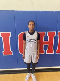 a young man standing in front of a basketball court