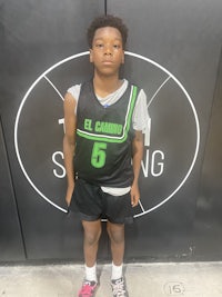 a young man standing in front of a basketball court