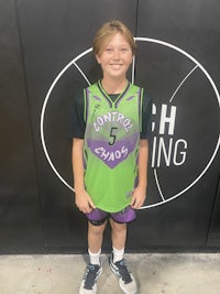 a young boy standing in front of a basketball court