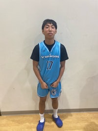 a young boy in a blue basketball uniform posing for a photo