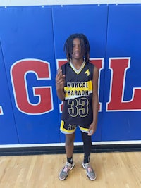 a young man in a basketball uniform posing for a picture