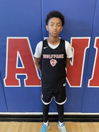 a young boy standing in front of a basketball court