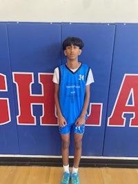 a young boy standing in front of a basketball court