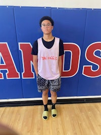 a young man standing in front of a basketball court