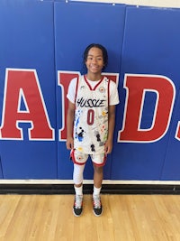 a girl in a basketball uniform standing in front of a wall