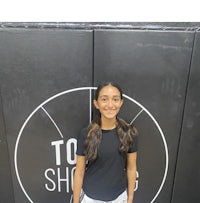 a young girl standing in front of a basketball court