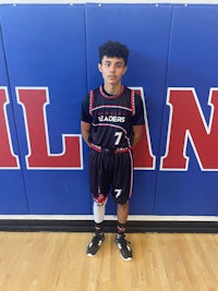 a young man in a basketball uniform standing in front of a wall