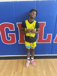 a young man standing in front of a basketball court