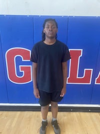 a young girl standing in front of a basketball court