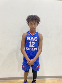 a young boy in a basketball uniform posing for a picture