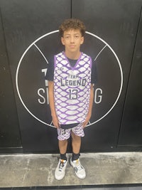 a young boy standing in front of a basketball court