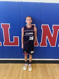 a young man in a basketball uniform standing in front of a wall