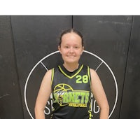 a young girl in a basketball uniform standing in front of a wall