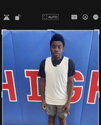 a young man is standing in front of a basketball court