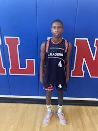 a young man standing in front of a basketball court