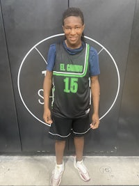 a young man standing in front of a basketball court