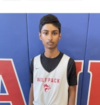 a young man in a basketball uniform standing in front of a wall