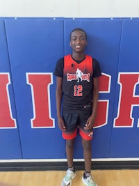 a young man standing in front of a basketball court