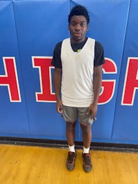 a young man standing in front of a basketball court