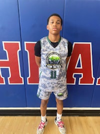 a young man in a basketball uniform standing in front of a wall