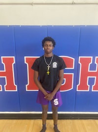 a young man standing in front of a basketball court