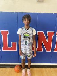 a young man in a basketball uniform standing in front of a wall