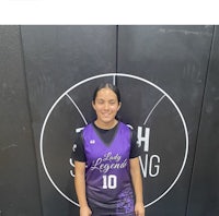 a woman in a purple uniform standing in front of a wall