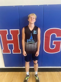 a young man standing in front of a basketball wall