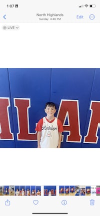 a picture of a boy standing in front of a basketball court