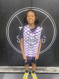 a girl wearing a purple and white basketball uniform