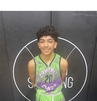 a young man in a basketball uniform standing in front of a wall