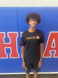 a young man standing in front of a basketball court